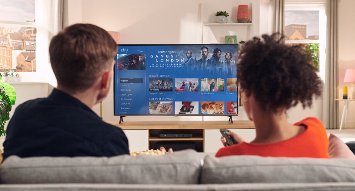 Sky living room image Two people in a living room watching Sky TV